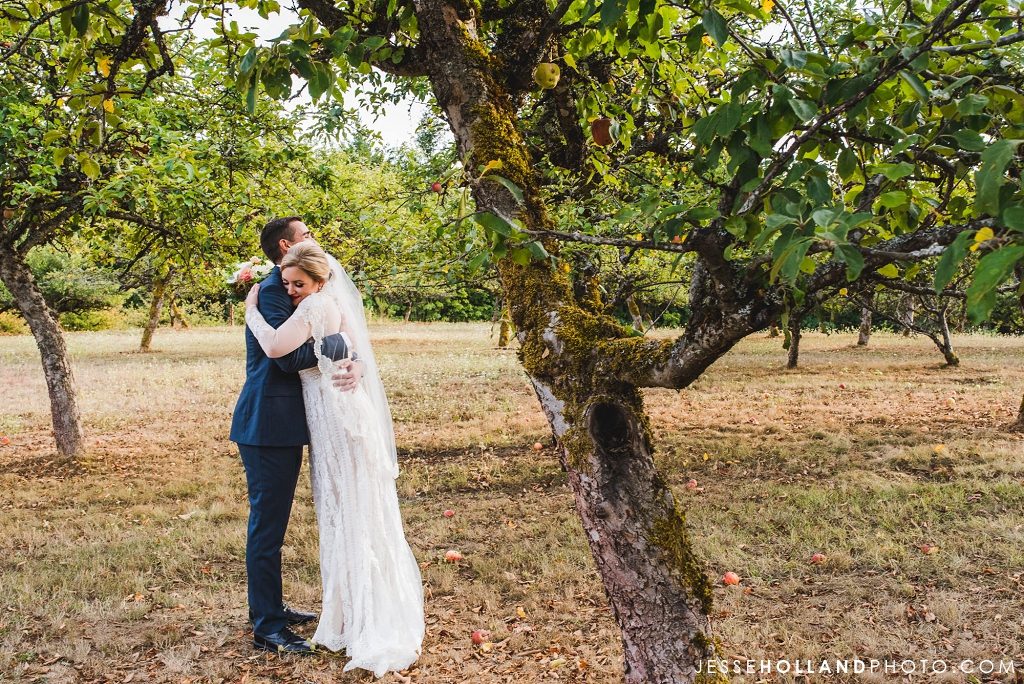couple hugging an an orchard
